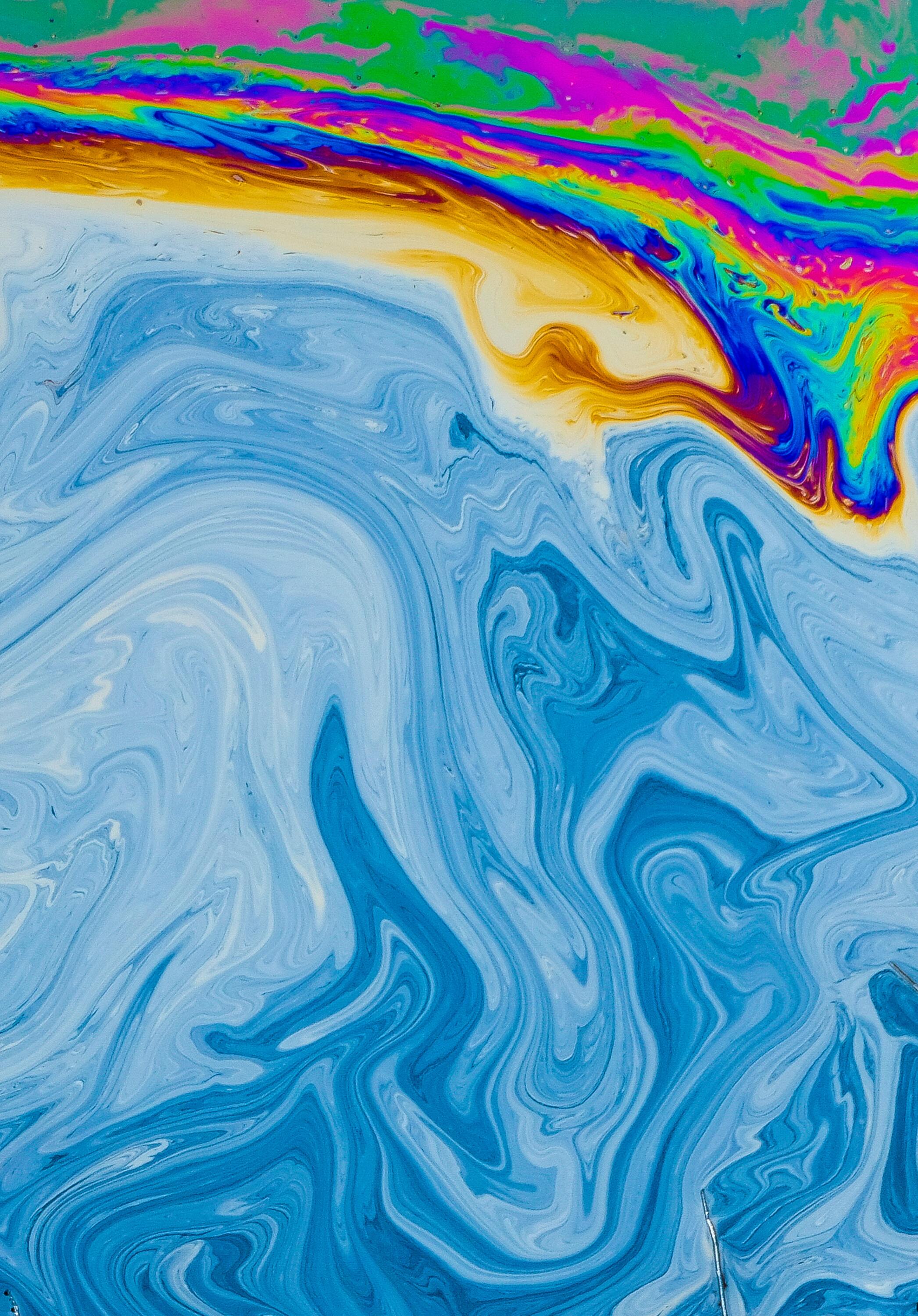 Image By Daniele Levis Pelusi, Un-splash. Bloue and white swirled paint in a portrait format.  Yellow, Pink, Darker blue and deep red are in swirls at the top.